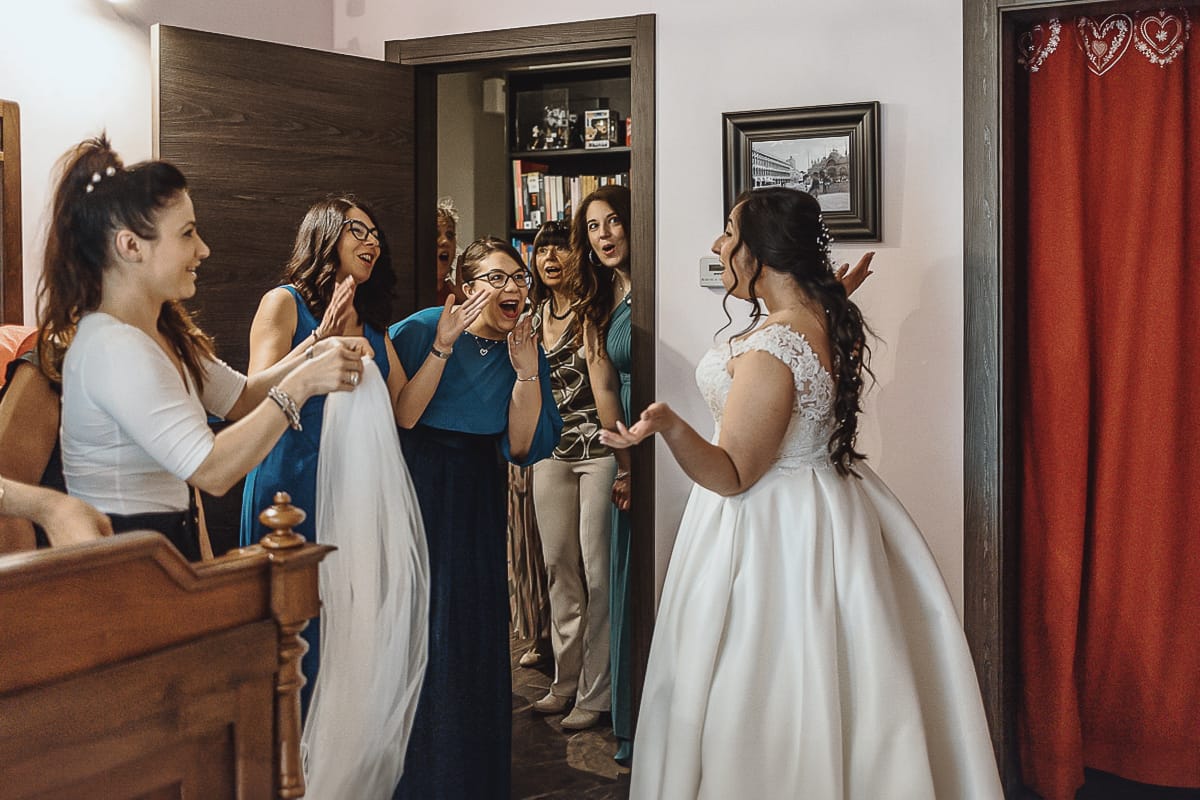 Matrimonio a Riva presso Chieri, preparazione della sposa.Amiche della sposa entrano e vedono la sposa con l'abito per la prima volta
