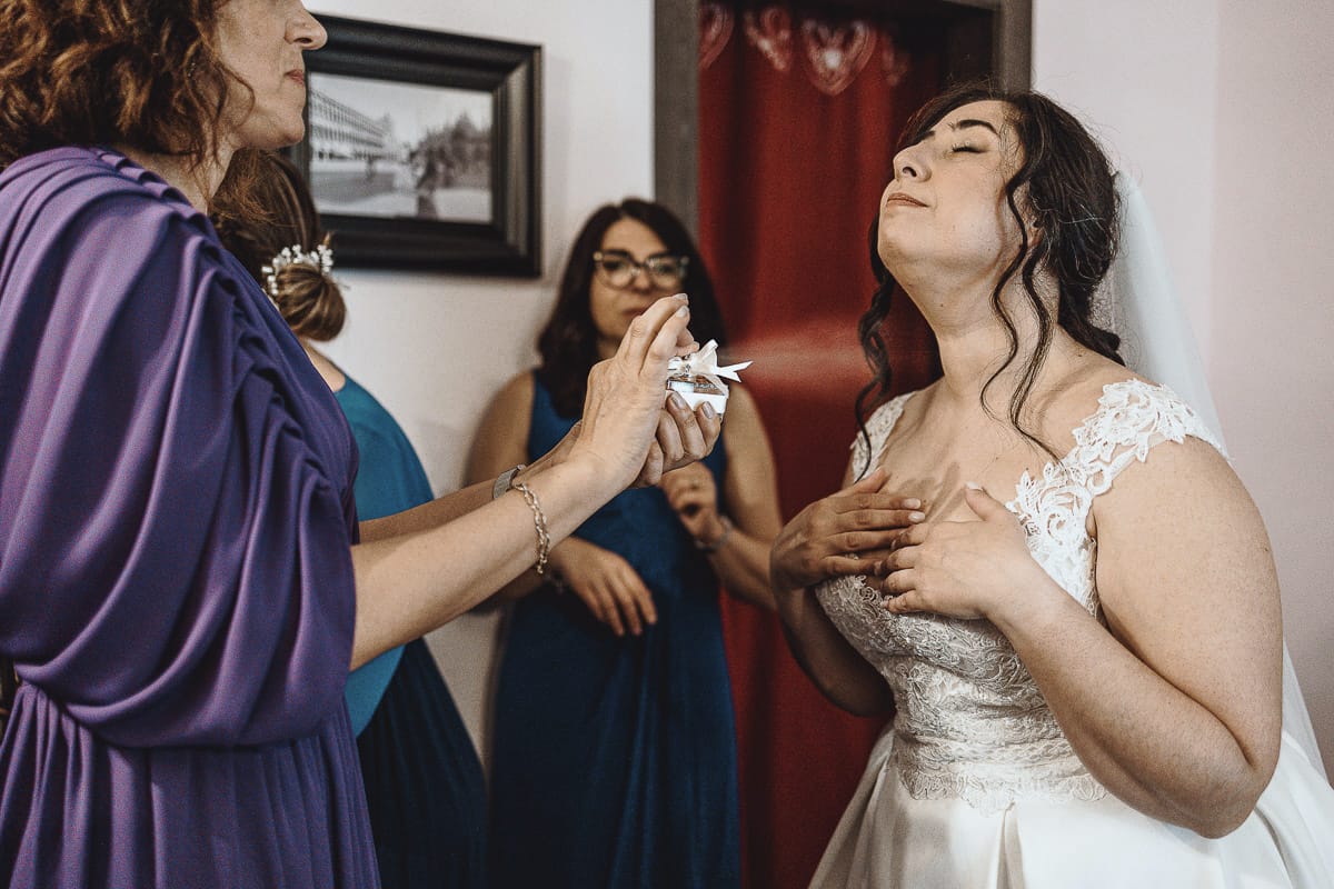 Matrimonio a Riva presso Chieri, preparazione della sposa. la testimone spruzza il profumo alla sposa