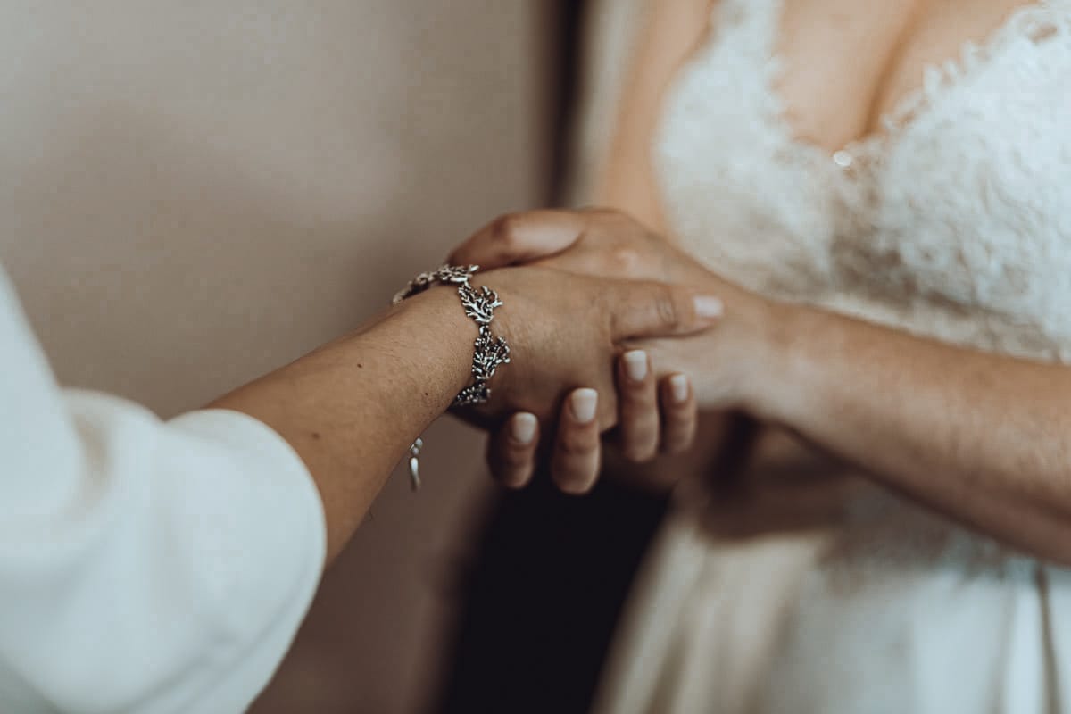 Matrimonio a Riva presso Chieri, preparazione della sposa. La sposa prende le mani di un'amica