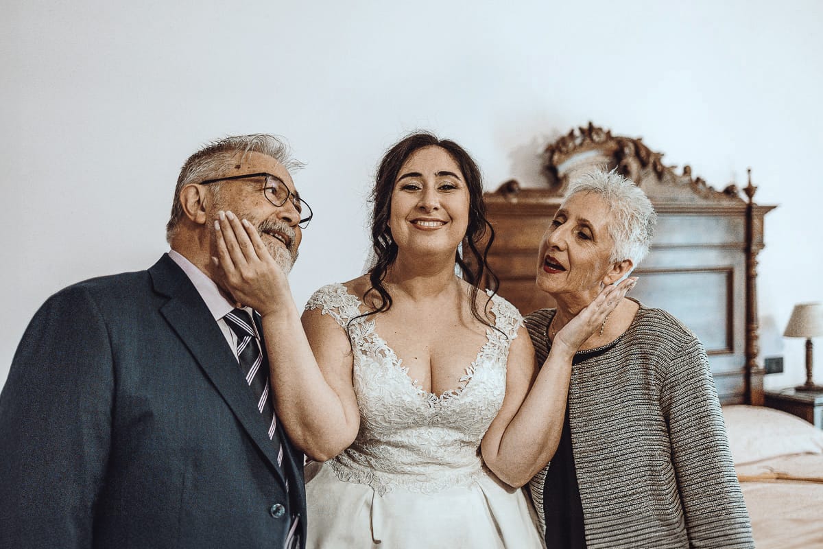 Matrimonio a Riva presso Chieri, preparazione della sposa. la sposa accarezza i genitori.