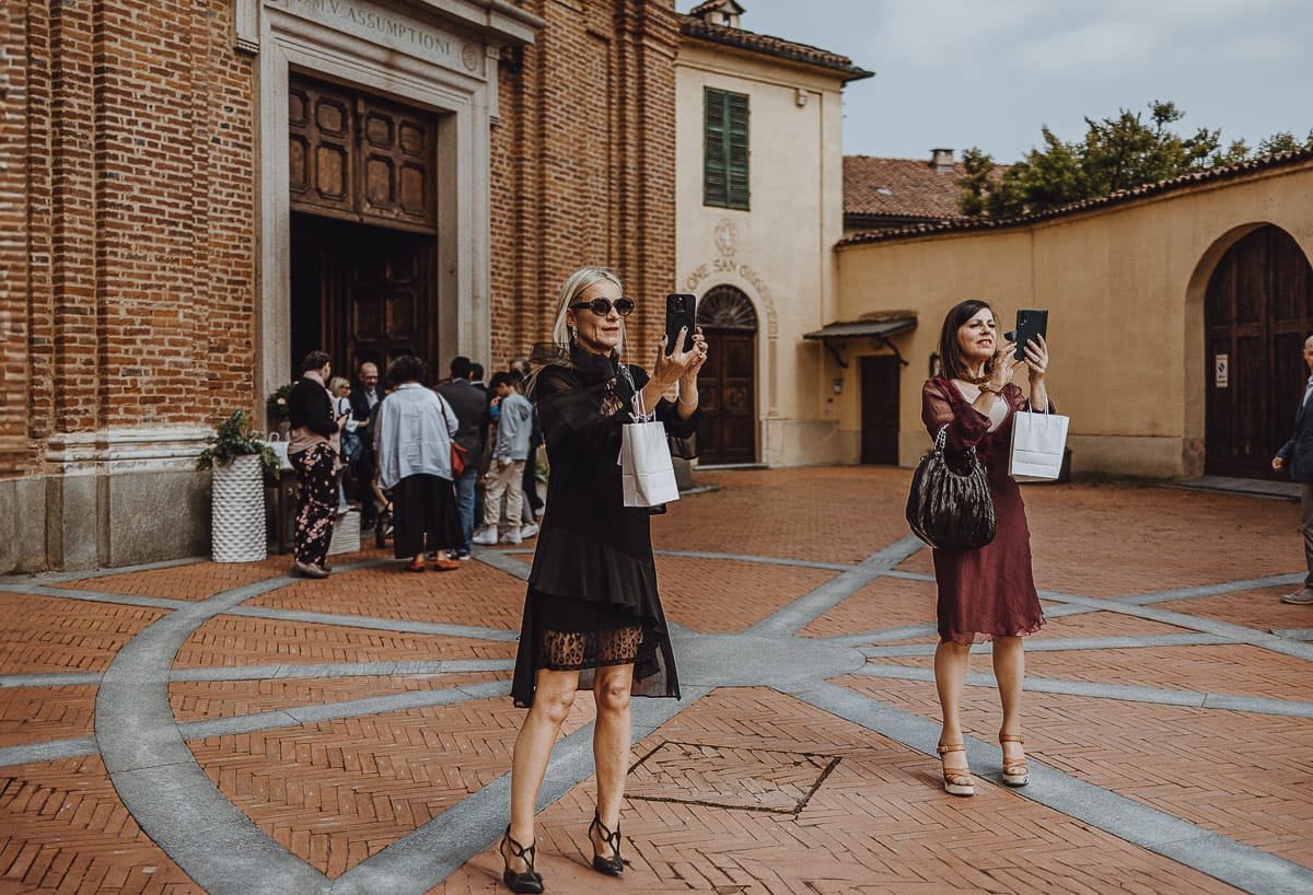 Matrimonio a Riva presso Chieri. Cerimonia. Invitate filamano l'arrivo della sposa davanti alla chiesa.