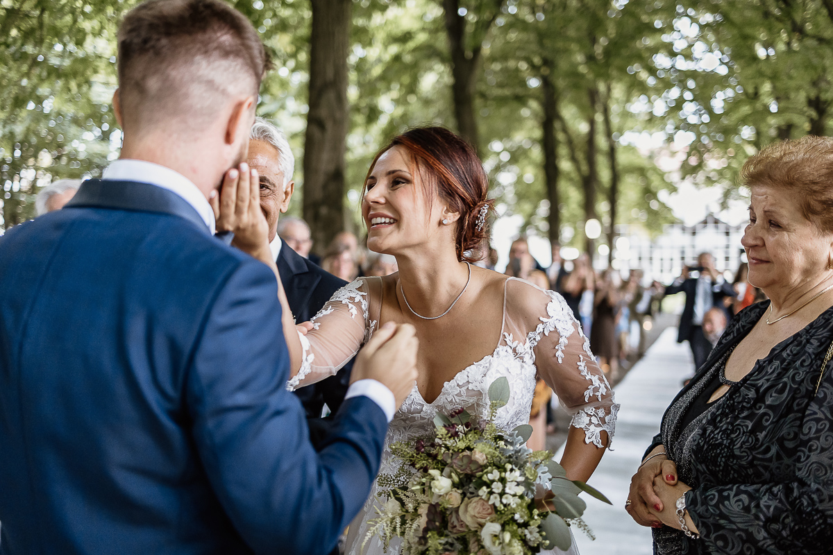 Castello dei Solaro, matrimonio di Noemi e Pietro. Cerimonia. Sposa accarezza e consola lo sposo commosso.