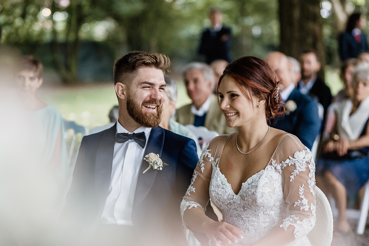 Castello dei Solaro, matrimonio di Noemi e Pietro. Cerimonia. Sposo guarda la sposa ridendo.