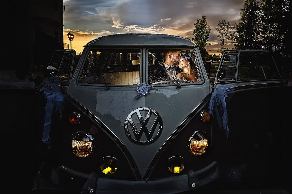 Castello dei Solaro, matrimonio di Noemi e Pietro. Sessione fotografica di coppia. Sposi dentro il van Wolkswagen al tramonto, illuminati da un flash esterno