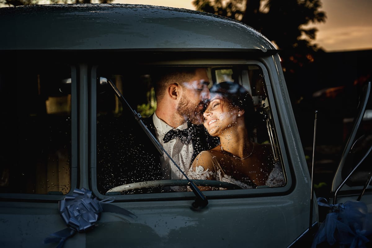 Castello dei Solaro, matrimonio di Noemi e Pietro. Sessione fotografica di coppia. Sposi dentro il Van Wolkswagen illuminati da un flash esterno, al tramonto