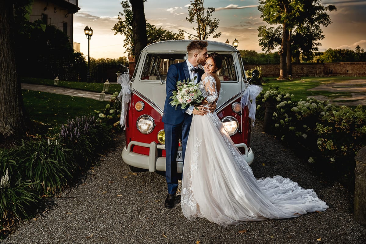 Castello dei Solaro, matrimonio di Noemi e Pietro. Sessione fotografica di coppia. Sposi fuori dal Van Wolkswagen rosso, al tramonto.