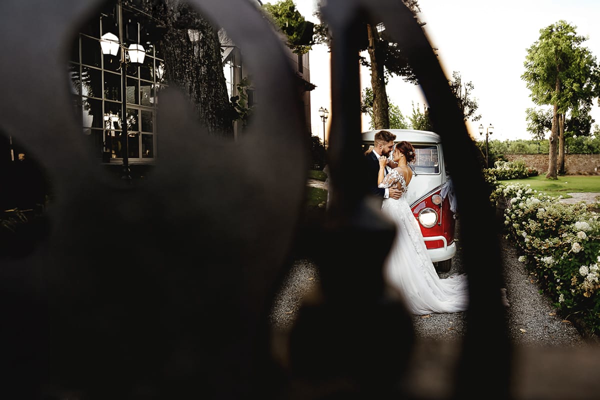 Castello dei Solaro, matrimonio di Noemi e Pietro. Sessione fotografica di coppia. Ritratto degli sposi attraverso il cancello in ferro battuto.