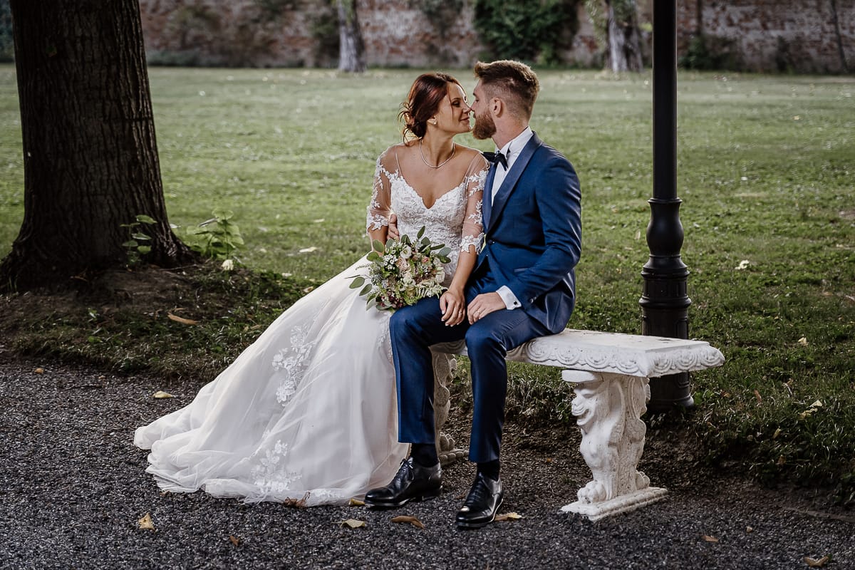 Castello dei Solaro, matrimonio di Noemi e Pietro. Sessione fotografica di coppia. Sposi seduiti su di una panchina. si baciano