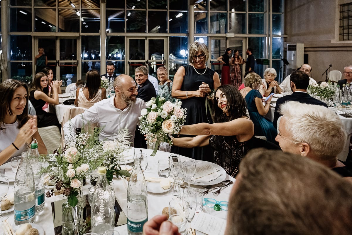 Castello dei Solaro, matrimonio di Noemi e Pietro. Cena. ragazza che ha preso il bouquet lo mostra al fidanzato.