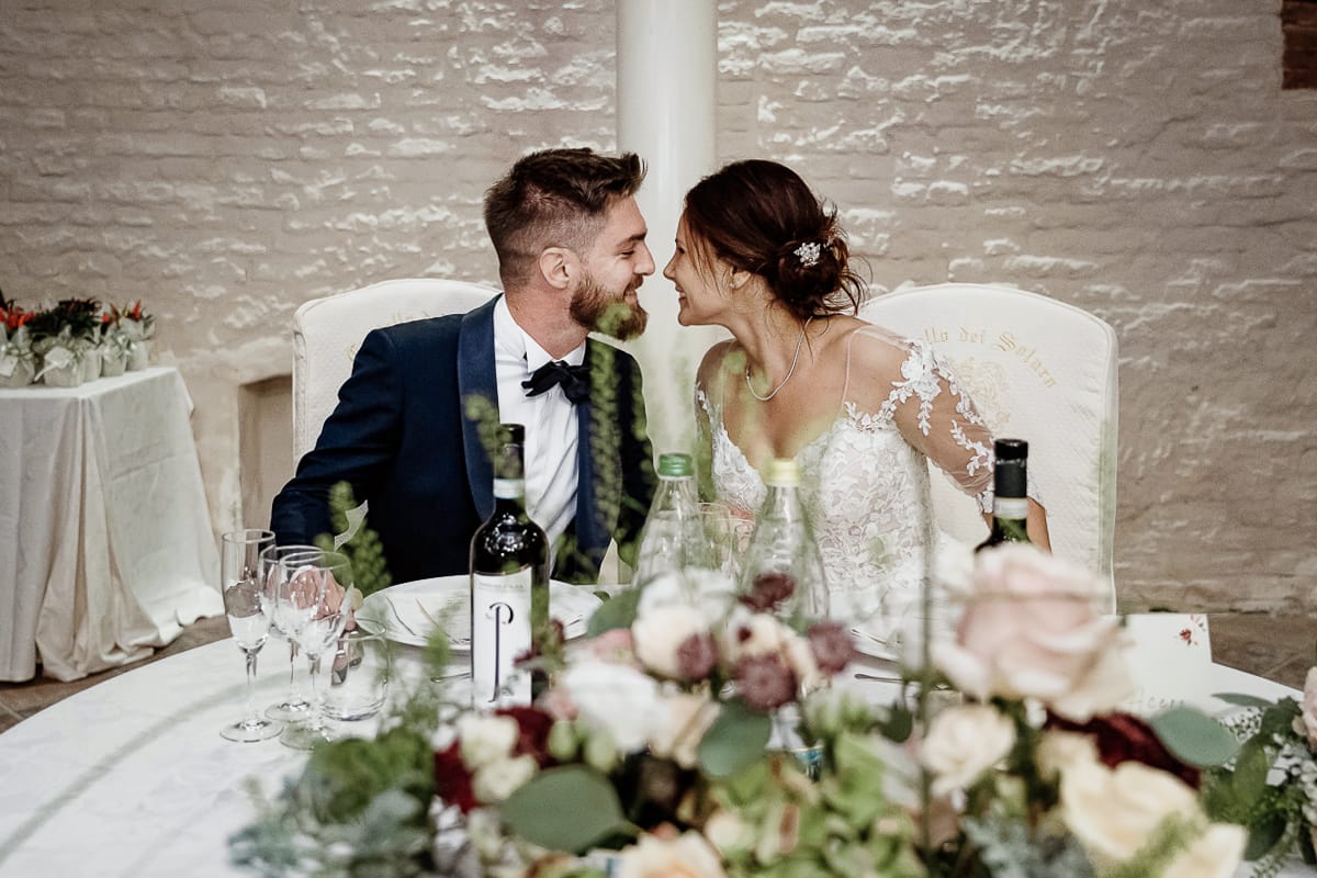 Castello dei Solaro, matrimonio di Noemi e Pietro. Cena. Sposi al loro tavolo che si guardano.