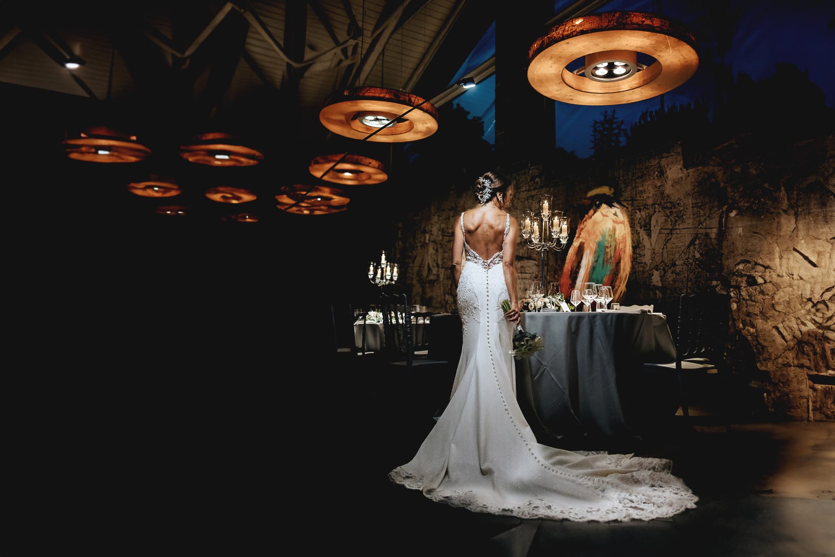 Matrimonio a "La Madernassa" nelle Langhe sotto la pioggia. Ritratto della sposa da dietro nella sala.