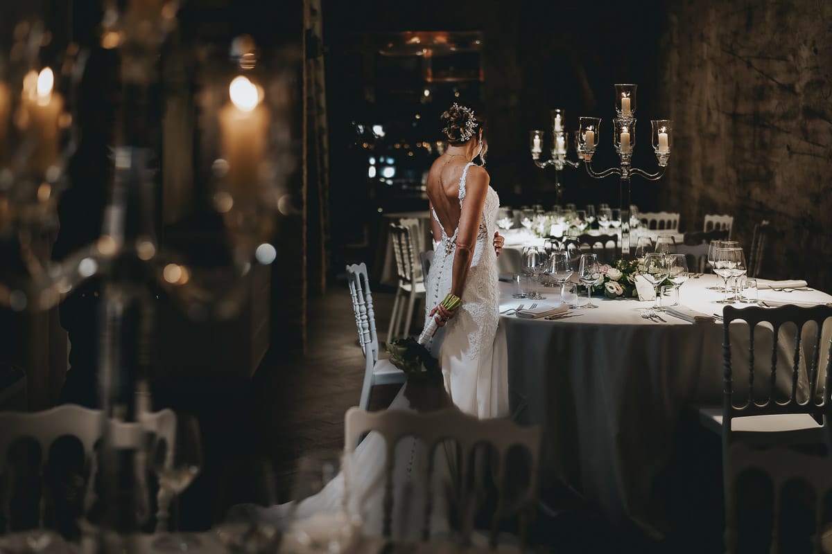 Matrimonio a "La Madernassa" nelle Langhe sotto la pioggia. Ritratto della sposa da dietro nella sala.