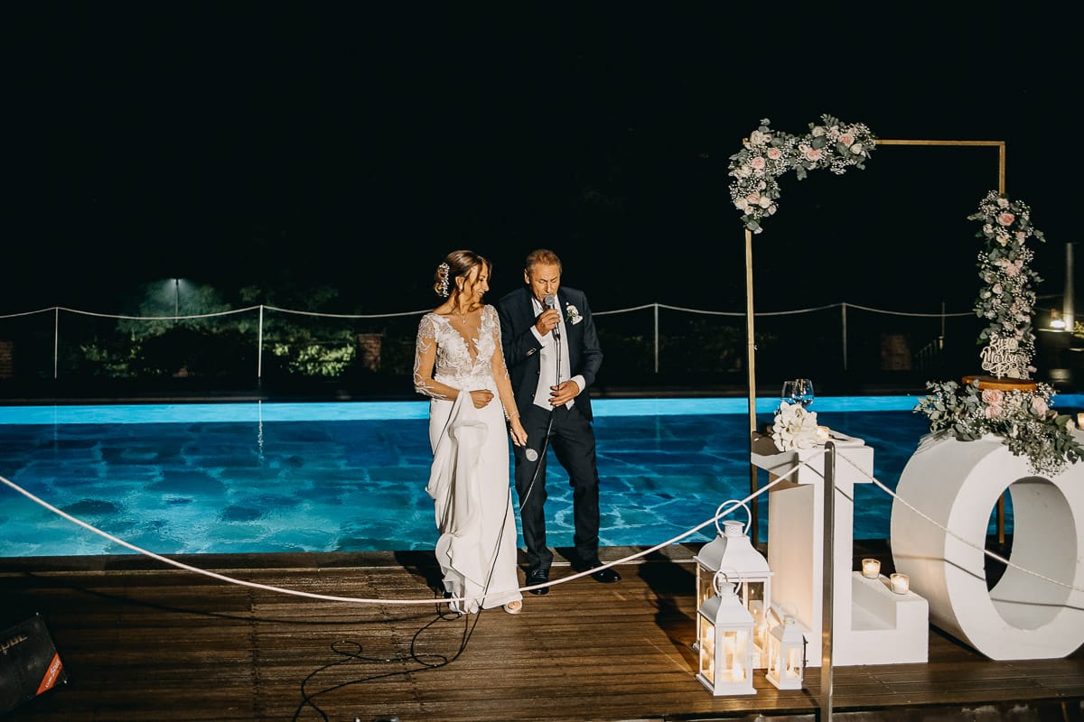 Matrimonio a "La Madernassa" nelle Langhe sotto la pioggia. Taglio torta. Allestimento luminoso, fiori e scritta LOVE.