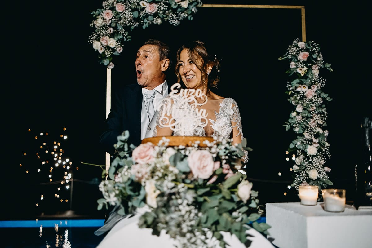 Matrimonio a "La Madernassa" nelle Langhe sotto la pioggia. Taglio torta. Allestimento luminoso, fiori e scritta LOVE.