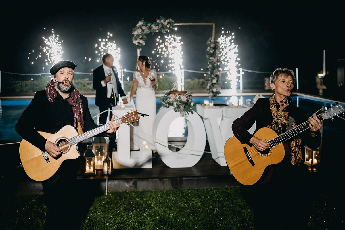 Matrimonio a "La Madernassa" nelle Langhe sotto la pioggia. Taglio torta. Allestimento luminoso, fiori e scritta LOVE. Musicisti.