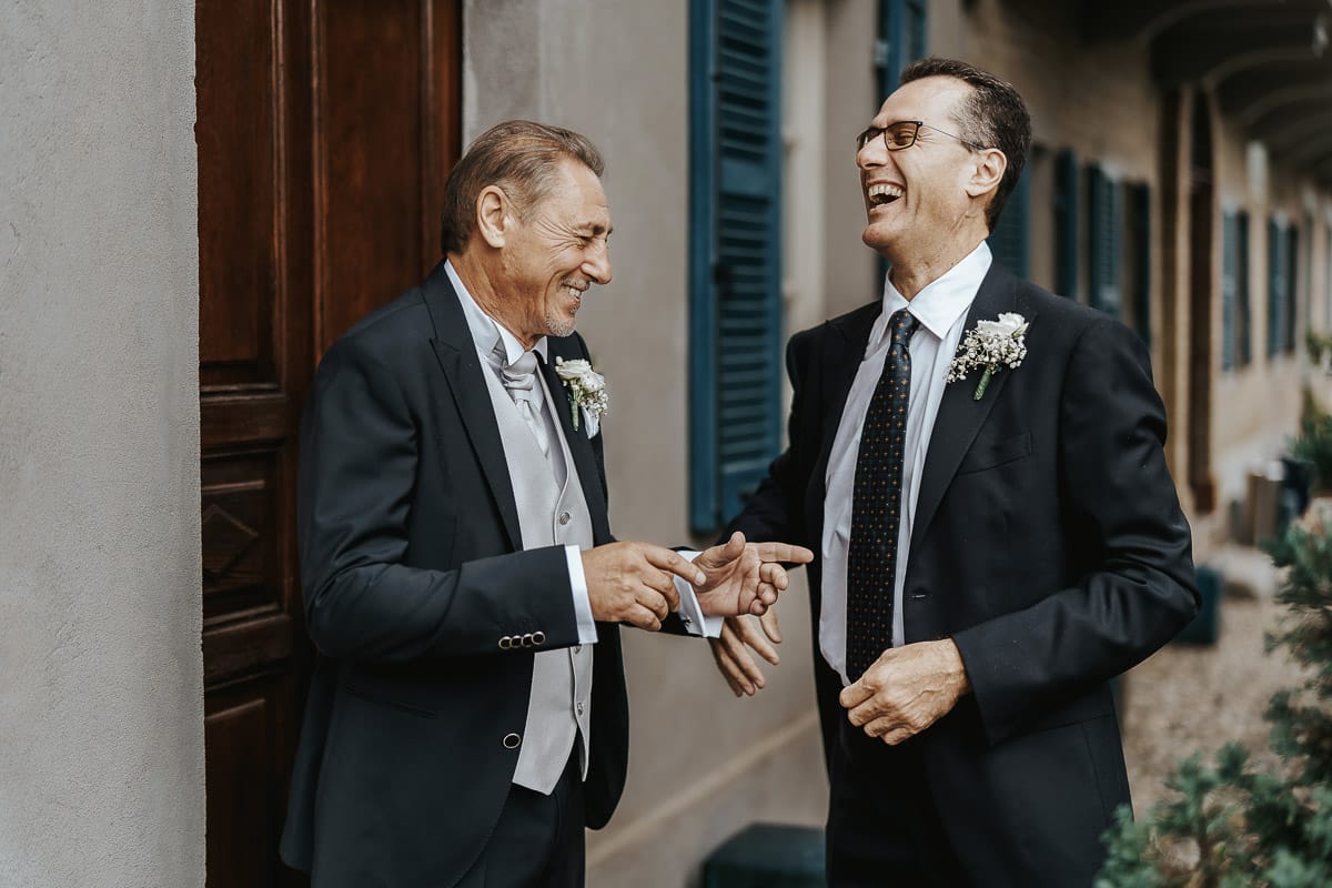 Matrimonio a "La Madernassa" nelle Langhe sotto la pioggia. preparazione dello sposo. Sposo ride con il testimone.