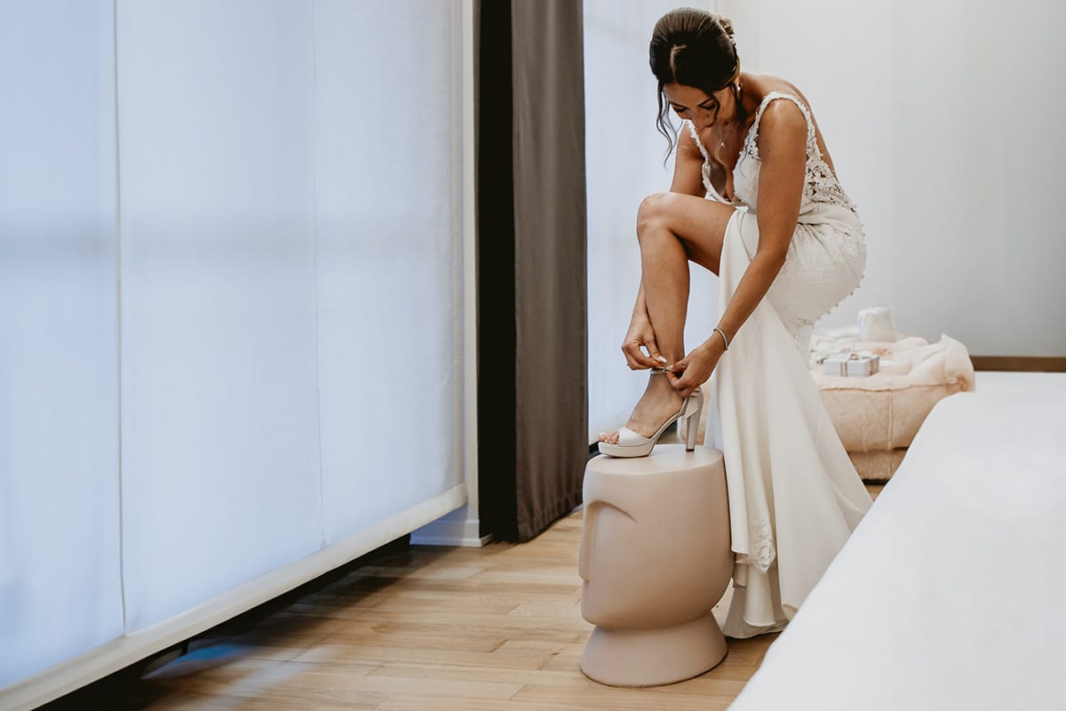 Matrimonio a "La Madernassa" nelle Langhe sotto la pioggia. Preparazione della sposa. Sposa si mette le scarpe.