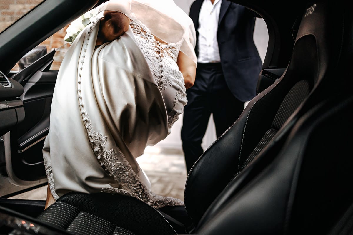 Matrimonio a "La Madernassa" nelle Langhe sotto la pioggia. Preparazione della sposa. Entrata della sposa nell'automobile.