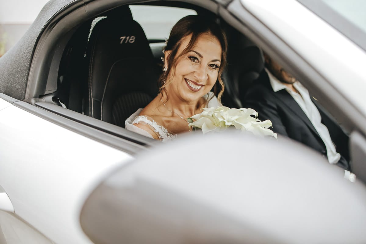 Matrimonio a "La Madernassa" nelle Langhe sotto la pioggia. Cerimonia. Sposa in auto.