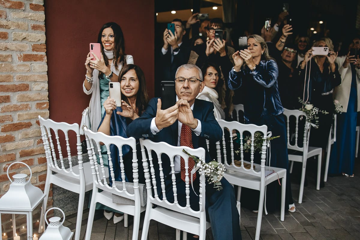 Matrimonio a "La Madernassa" nelle Langhe sotto la pioggia. Cerimonia. Ospiti guardano l'ingresso della sposa.