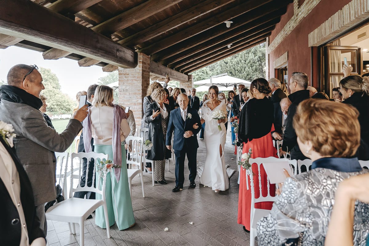 Matrimonio a "La Madernassa" nelle Langhe sotto la pioggia. Cerimonia. Ingresso della sposa con il padre.