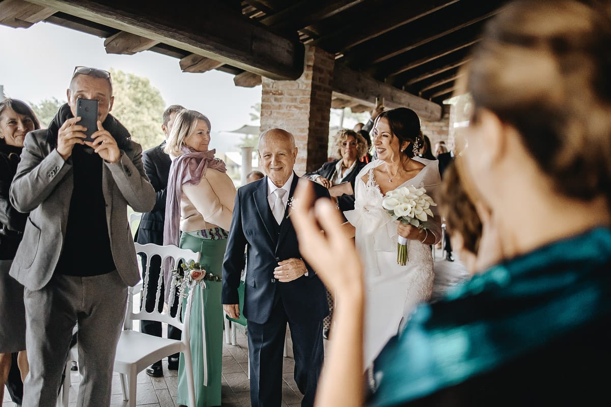Matrimonio a "La Madernassa" nelle Langhe sotto la pioggia. Cerimonia. Ingresso della sposa con il padre.