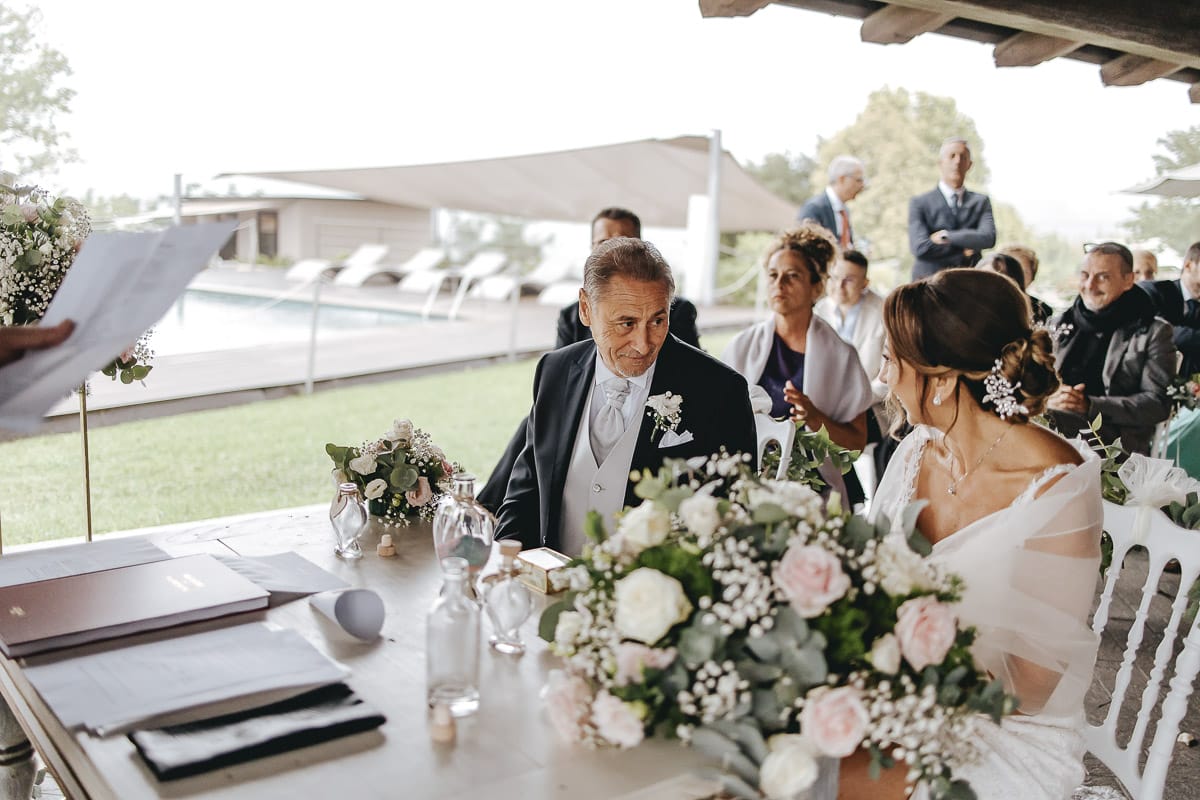 Matrimonio a "La Madernassa" nelle Langhe sotto la pioggia. Cerimonia. Sposo guarda la sposa