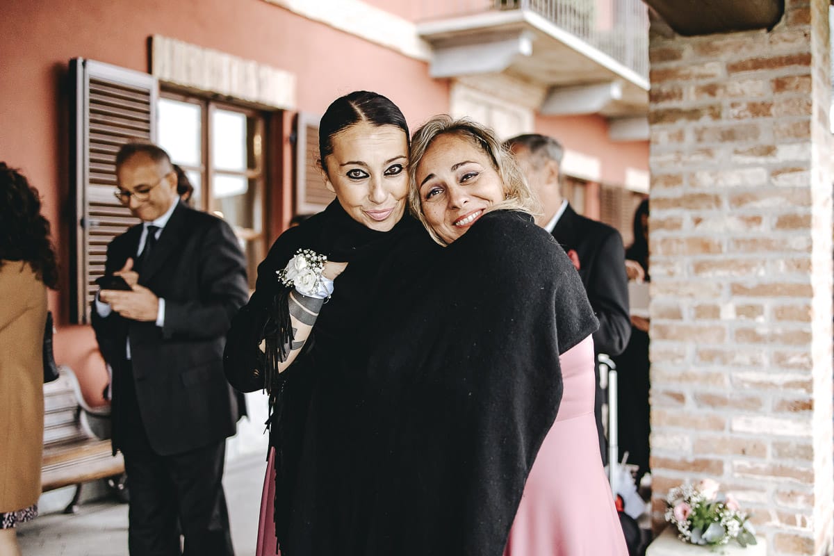 Matrimonio a "La Madernassa" nelle Langhe sotto la pioggia. Cerimonia. Damigelle avvolte nello scialle per il freddo.