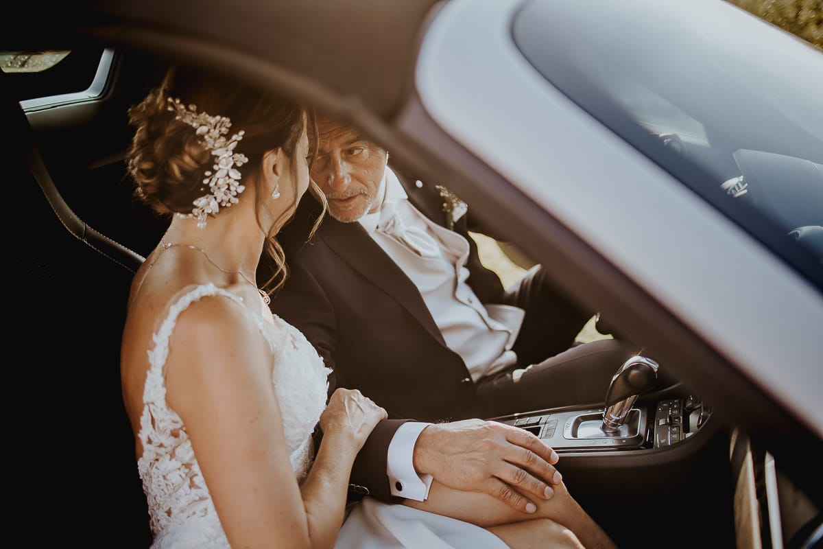 Post wedding a La Madernassa. Sposi all'esterno dentro la Porsche bianca.