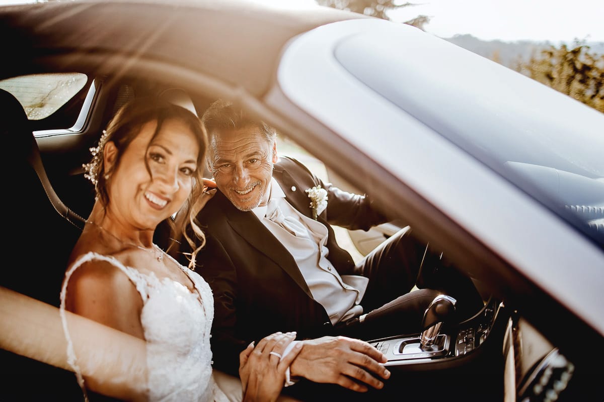 Post wedding a La Madernassa. Sposi all'esterno dentro la Porsche bianca.