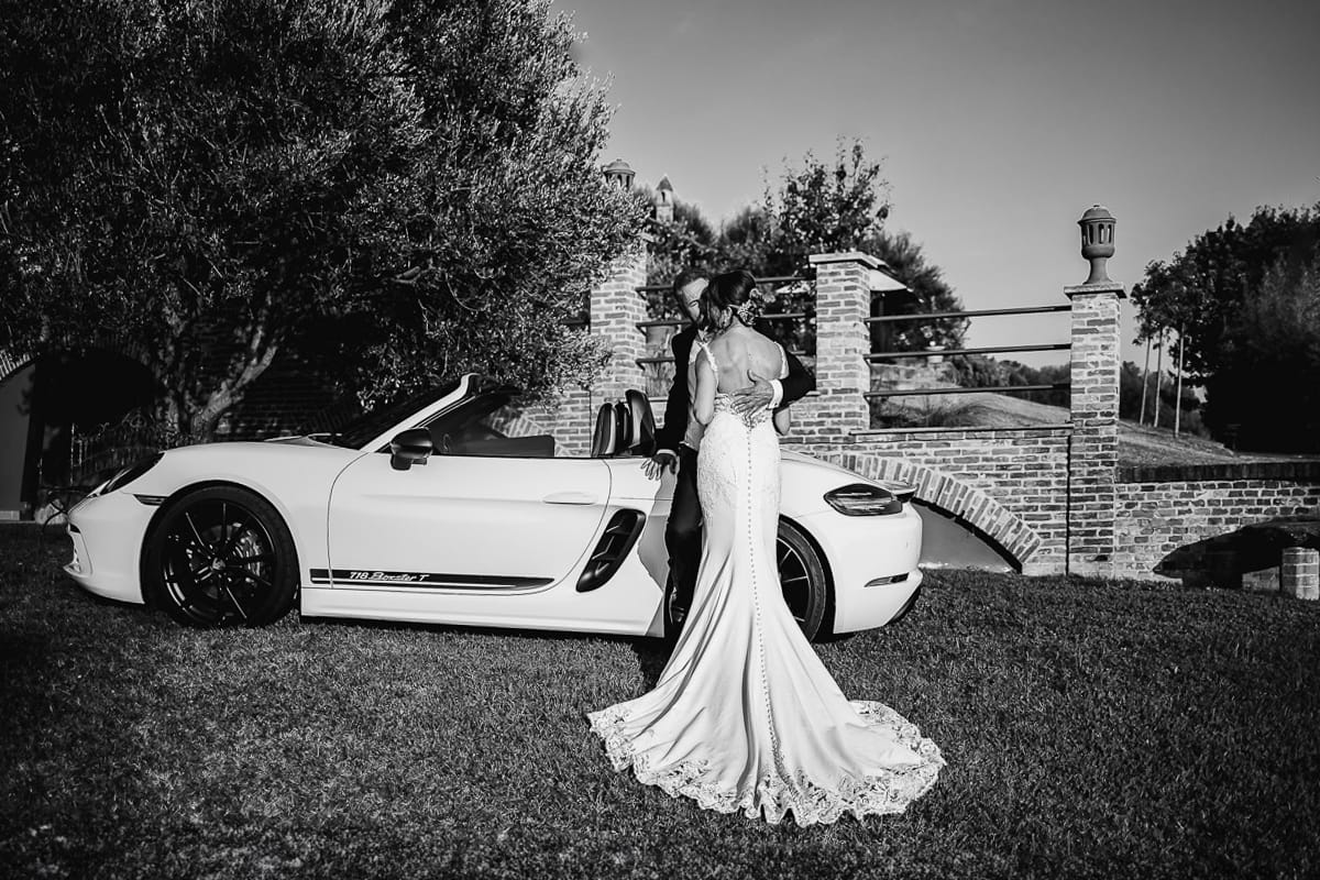 Post wedding a La Madernassa. Sposi all'esterno vicino alla Porsche bianca.