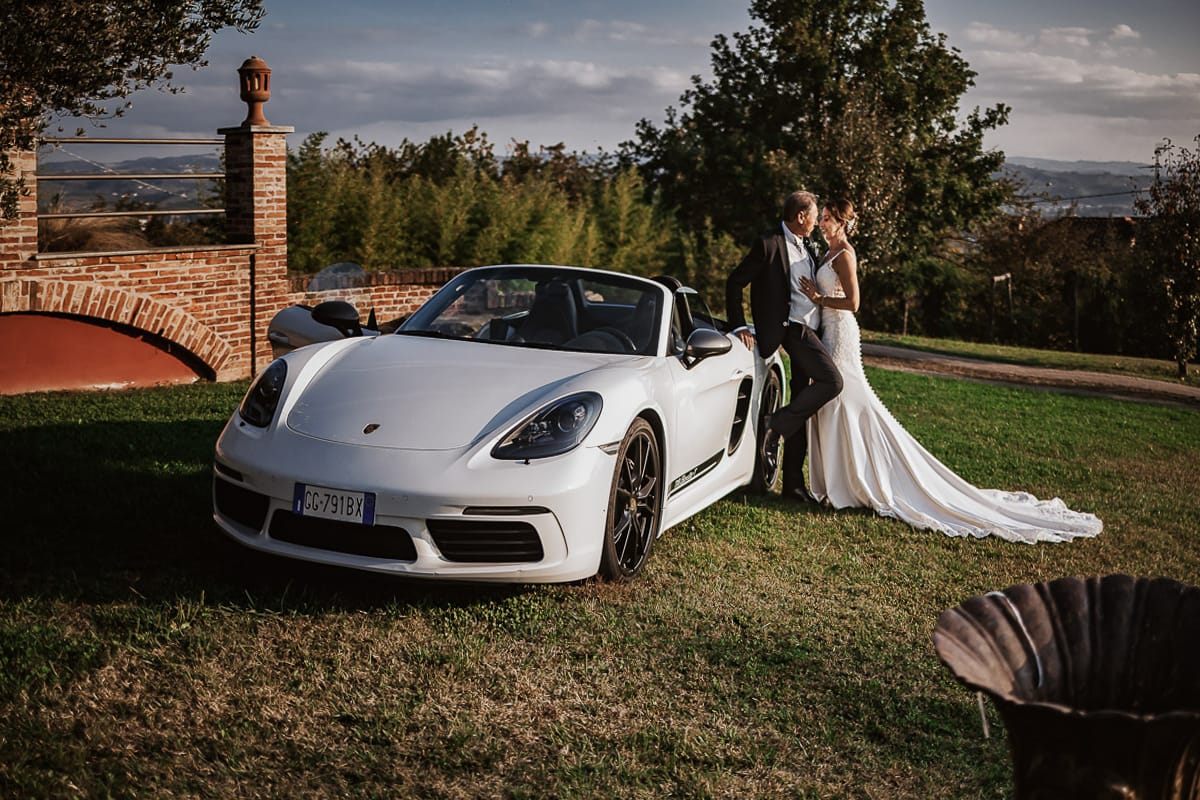 Post wedding a La Madernassa. Sposi all'esterno vicino alla Porsche bianca.