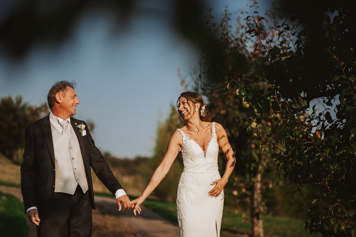 Post wedding a La Madernassa. Sposi passeggiano tra i peri che danno il nome alla location