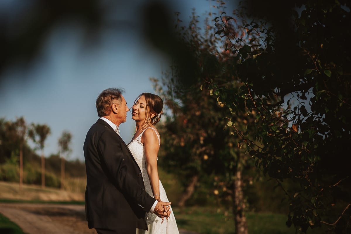 Post wedding a La Madernassa. Sposi passeggiano tra i peri che danno il nome alla location si guardano