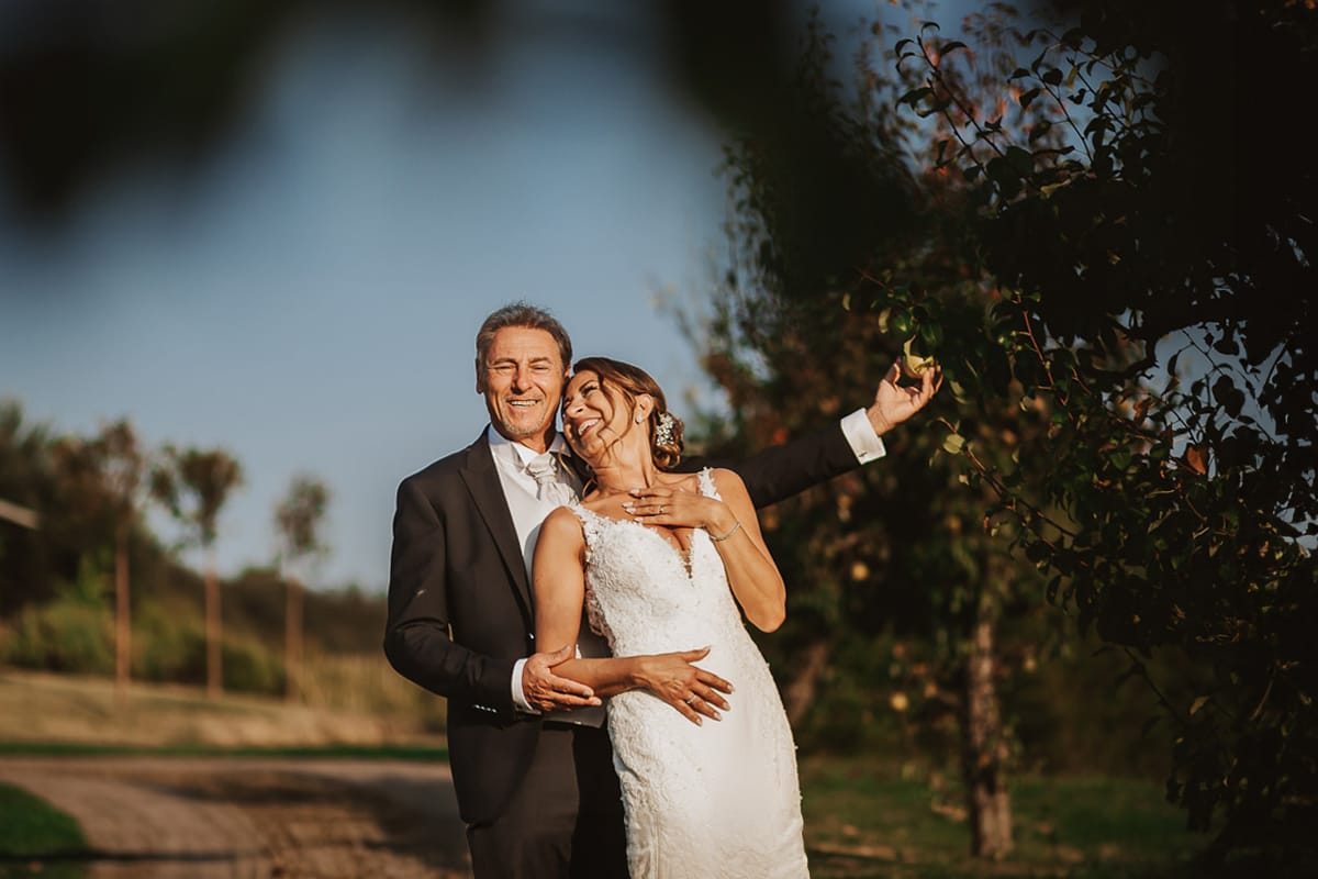 Post wedding a La Madernassa. Sposi passeggiano tra i peri che danno il nome alla location