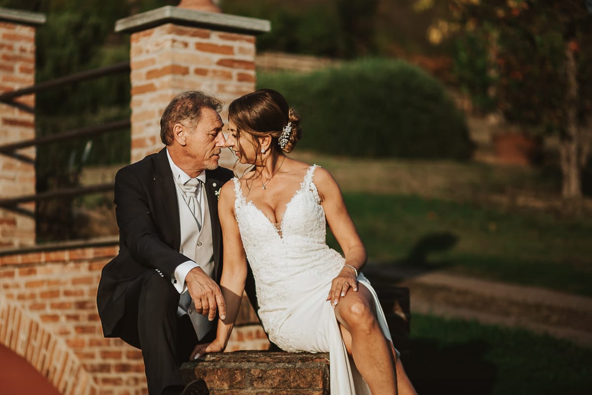 Post wedding a La Madernassa. Sposi seduti su di un muretto di mattoni