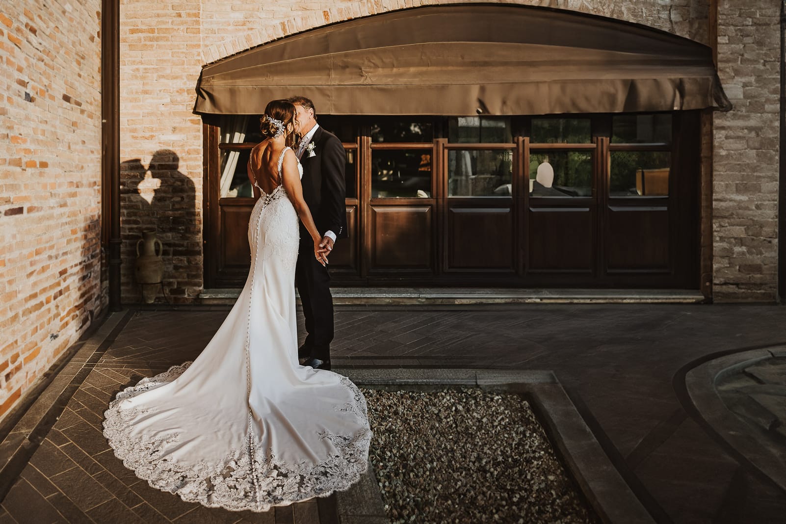 Post wedding a La Madernassa. Ritratto degli sposi con ombra proiettata sul muro di matton