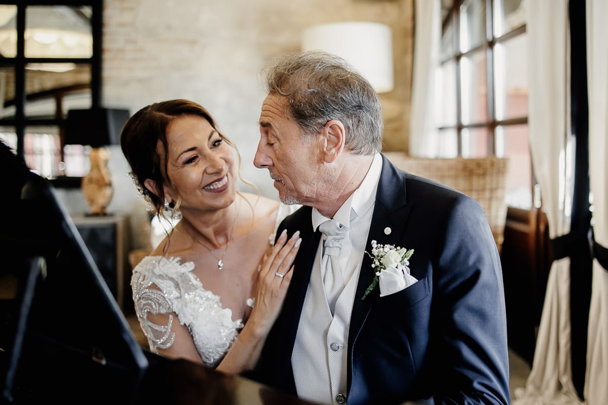 Post wedding a La Madernassa. Sposo suona il pianoforte. Sposa lo guarda appoggiando le mani sul suo braccio