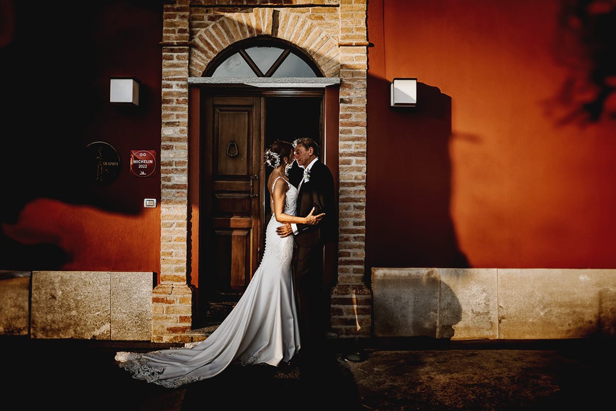 Post wedding a La Madernassa. Sposi davanti al portoncino di ingresso. Flash esterno dietro gli sposi.