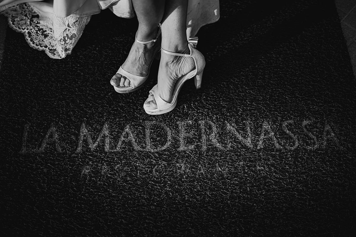 Post wedding a La Madernassa. Particolare delle scarpe della sposa sul tappetino d'ingresso col nome della location