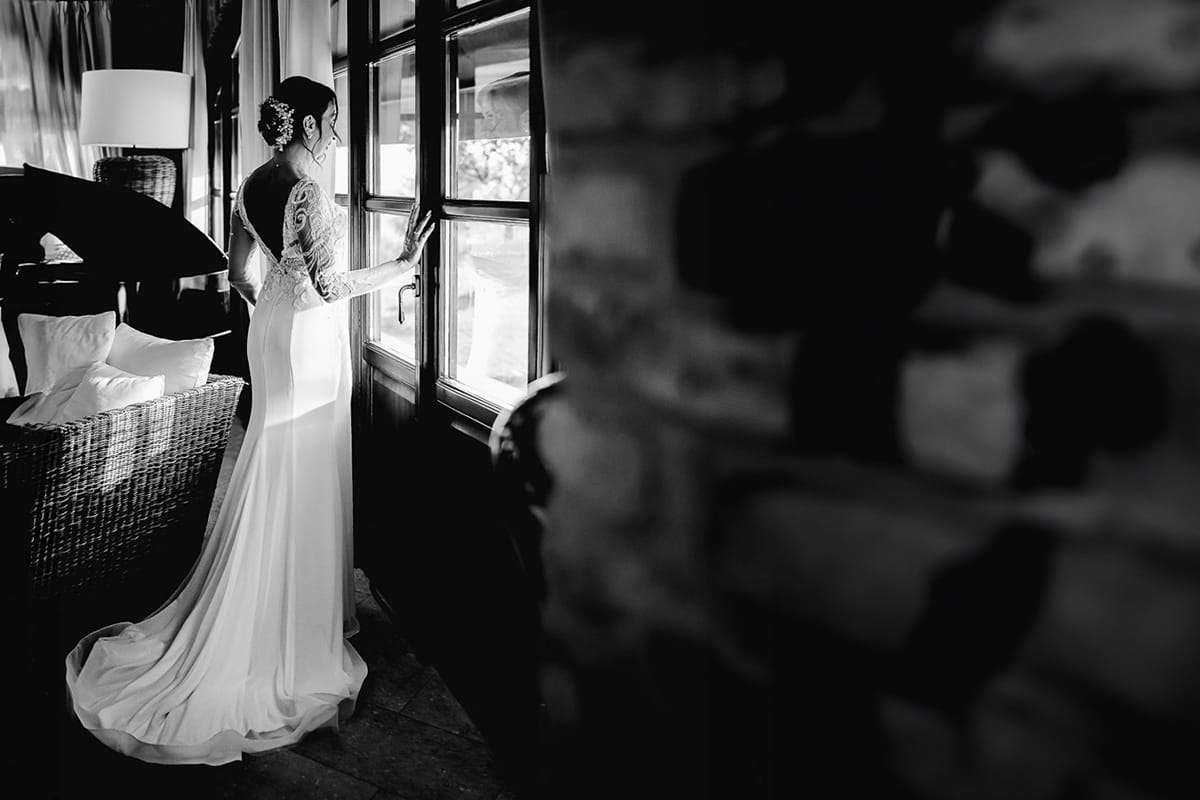 Post wedding a La Madernassa. Ritratto della sposa che guarda l'esterno da una vetrata