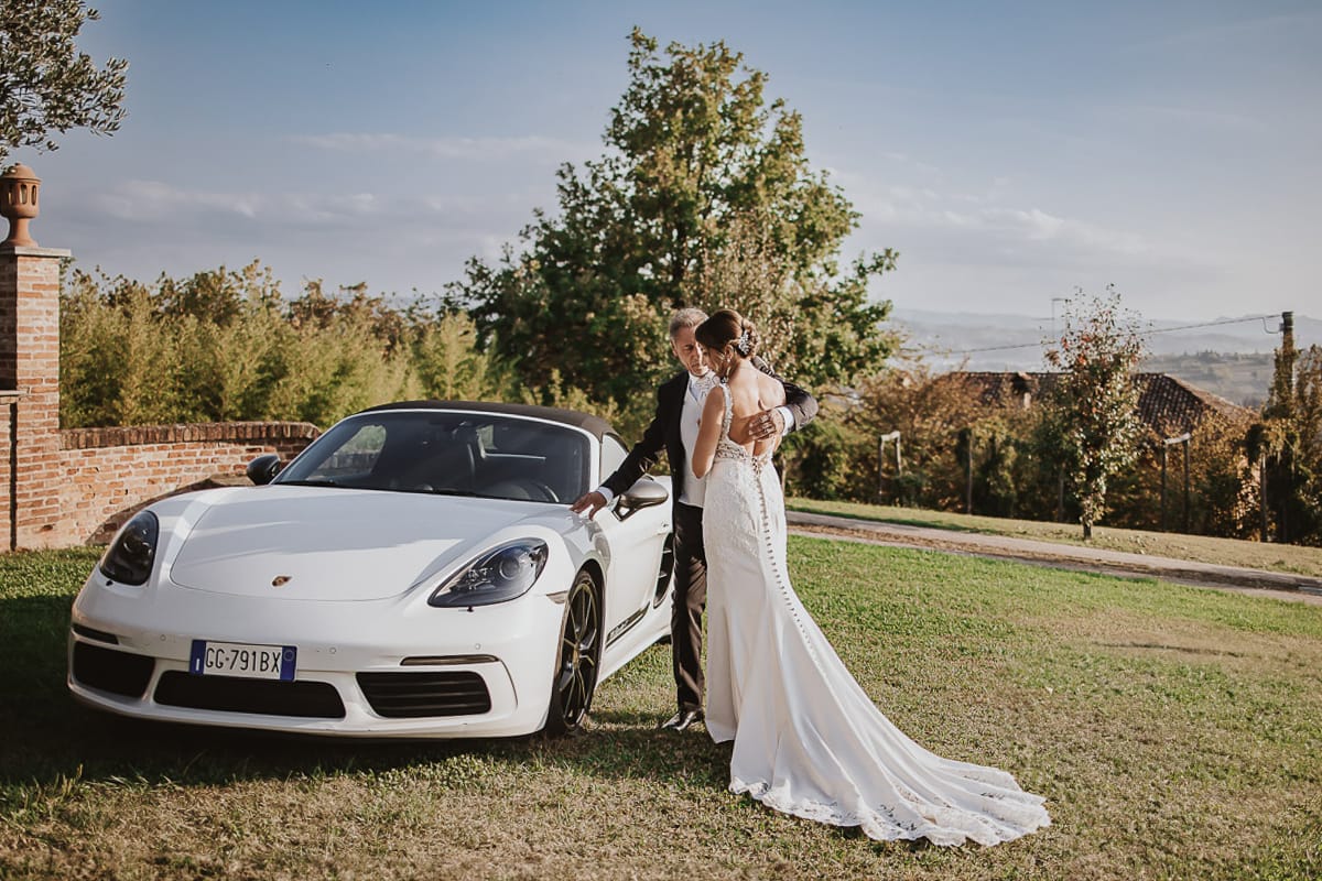 Post wedding a La Madernassa. Sposi all'esterno vicino alla Porsche bianca.