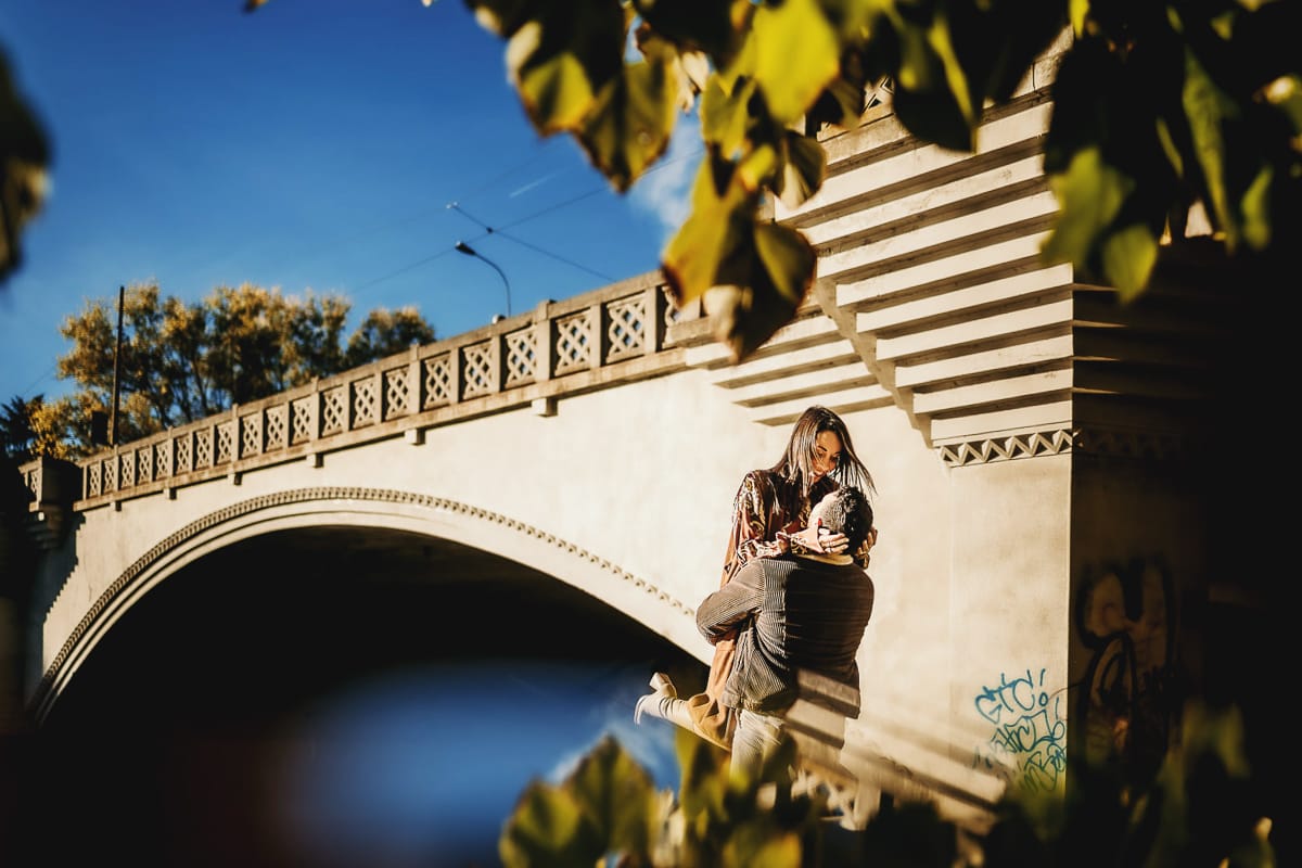 Prewedding a Torino, sul lungo Po al tramonto. La coppia si bacia. Il ragazzo prende la ragazza in braccio davanti al ponte sul Po.