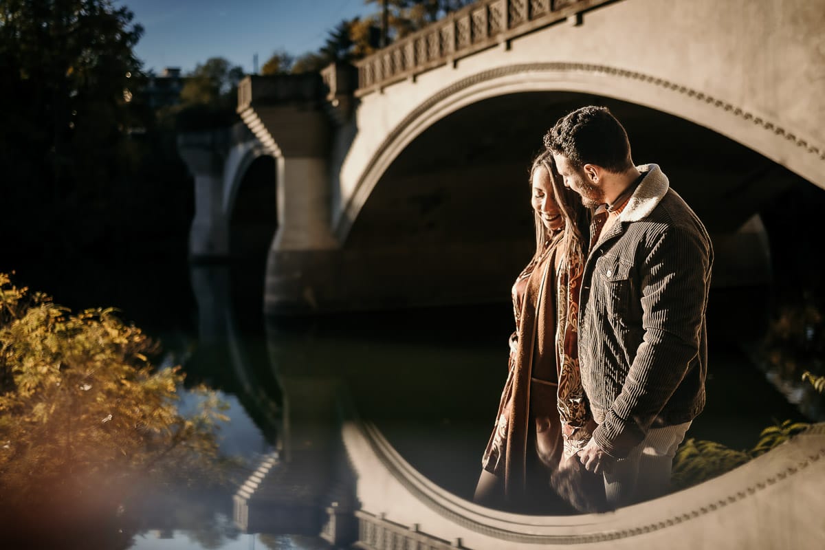 Prewedding a Torino, sul lungo Po al tramonto. Ritratto intimo della coppia sotto il ponte sul fiume. Riflessione in uno specchio.