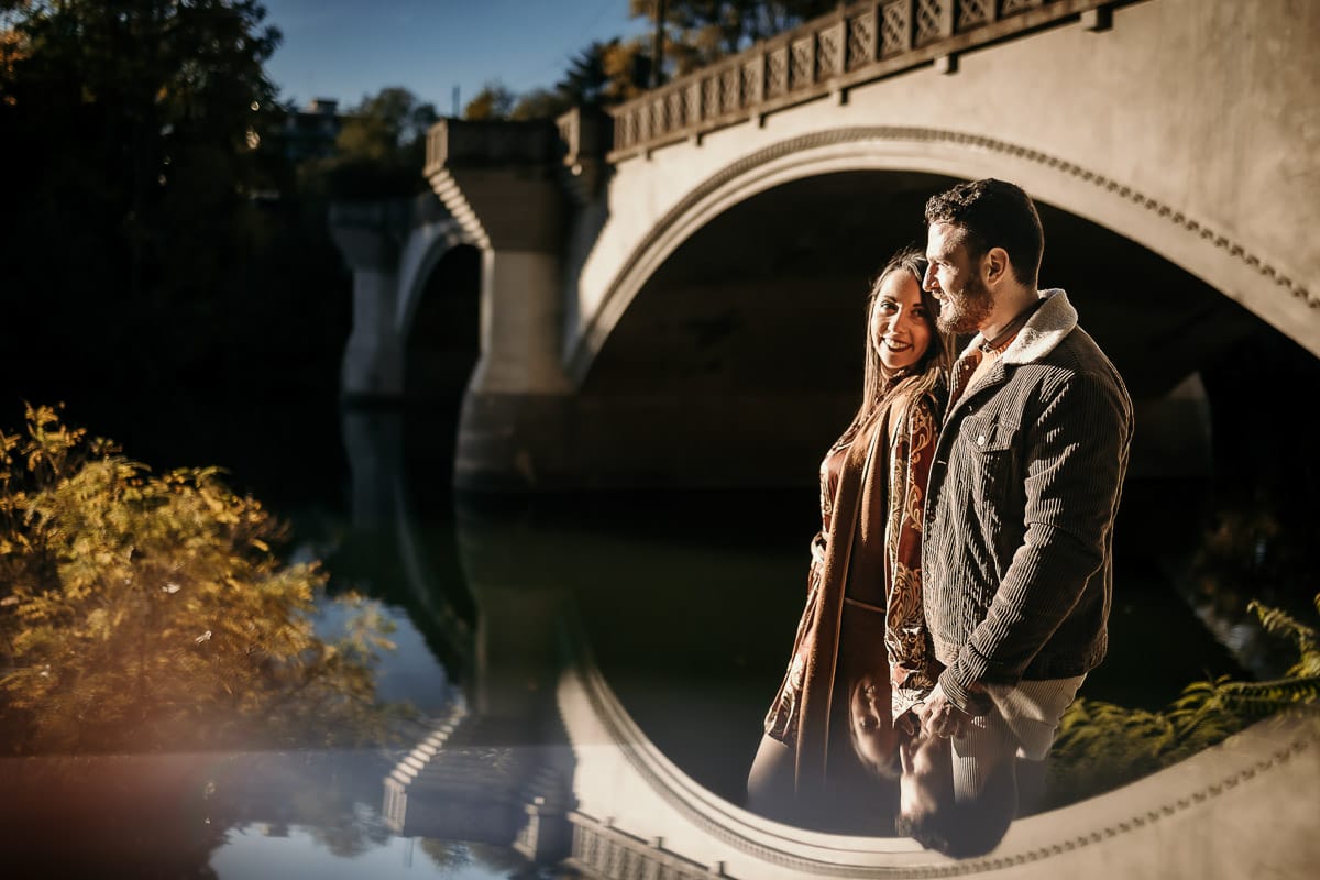 Prewedding a Torino, sul lungo Po al tramonto. Ritratto intimo della coppia sotto il ponte sul fiume. Riflessione in uno specchio.