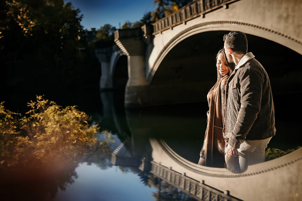 Prewedding a Torino, sul lungo Po al tramonto. Ritratto intimo della coppia sotto il ponte sul fiume. Riflessione in uno specchio.