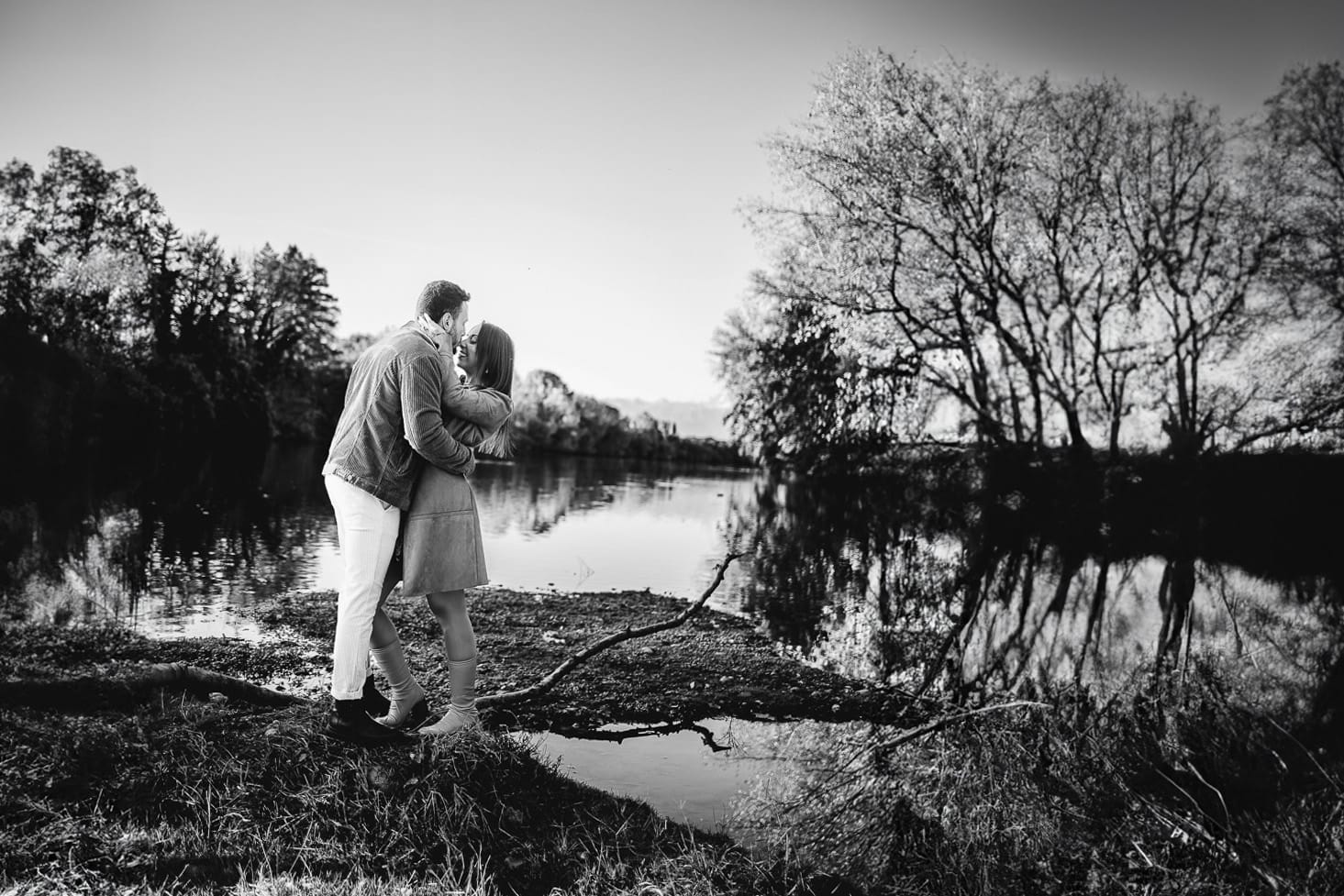 Prewedding a Torino, sul lungo Po al tramonto. Ritratto sulla riva del fiume con la magia dell'autunno sull'acqua. Bianco e nero.