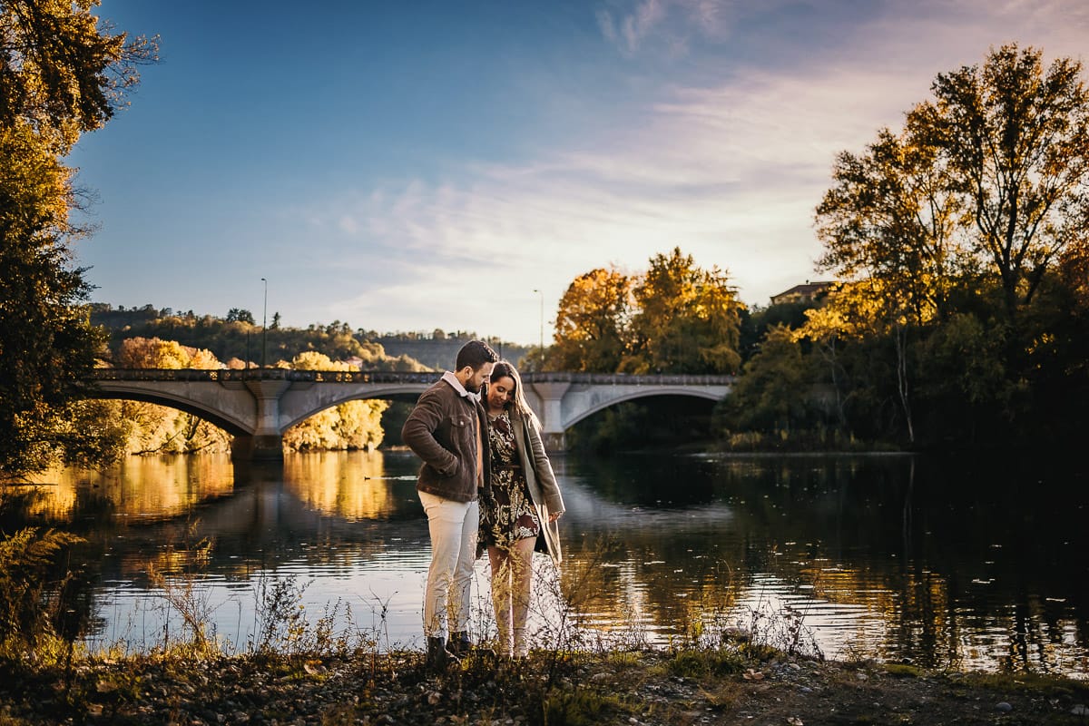 Prewedding a Torino, sul lungo Po al tramonto. Ritratto sulla riva del fiume con la magia dell'autunno sull'acqua. Sullo sfondo il ponte