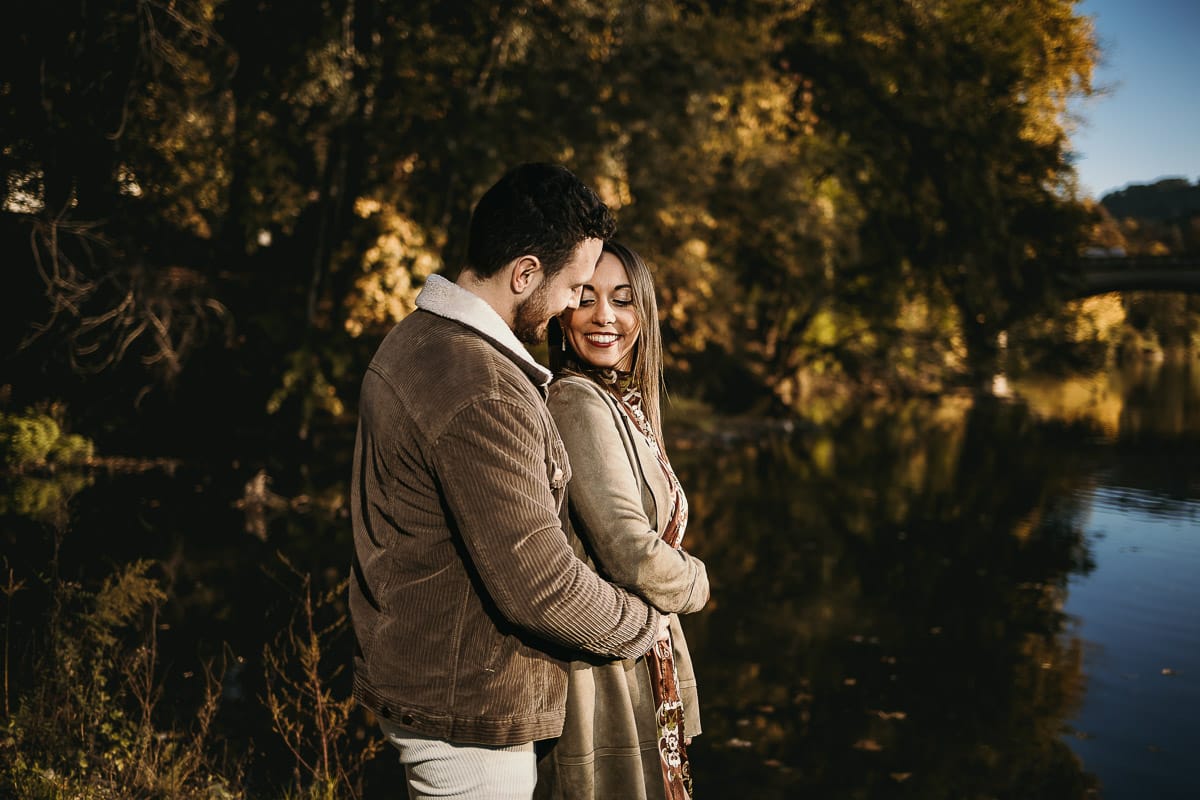 Prewedding a Torino, sul lungo Po al tramonto. Ritratto sulla riva del fiume con la magia dell'autunno sull'acqua. Sullo sfondo il ponte