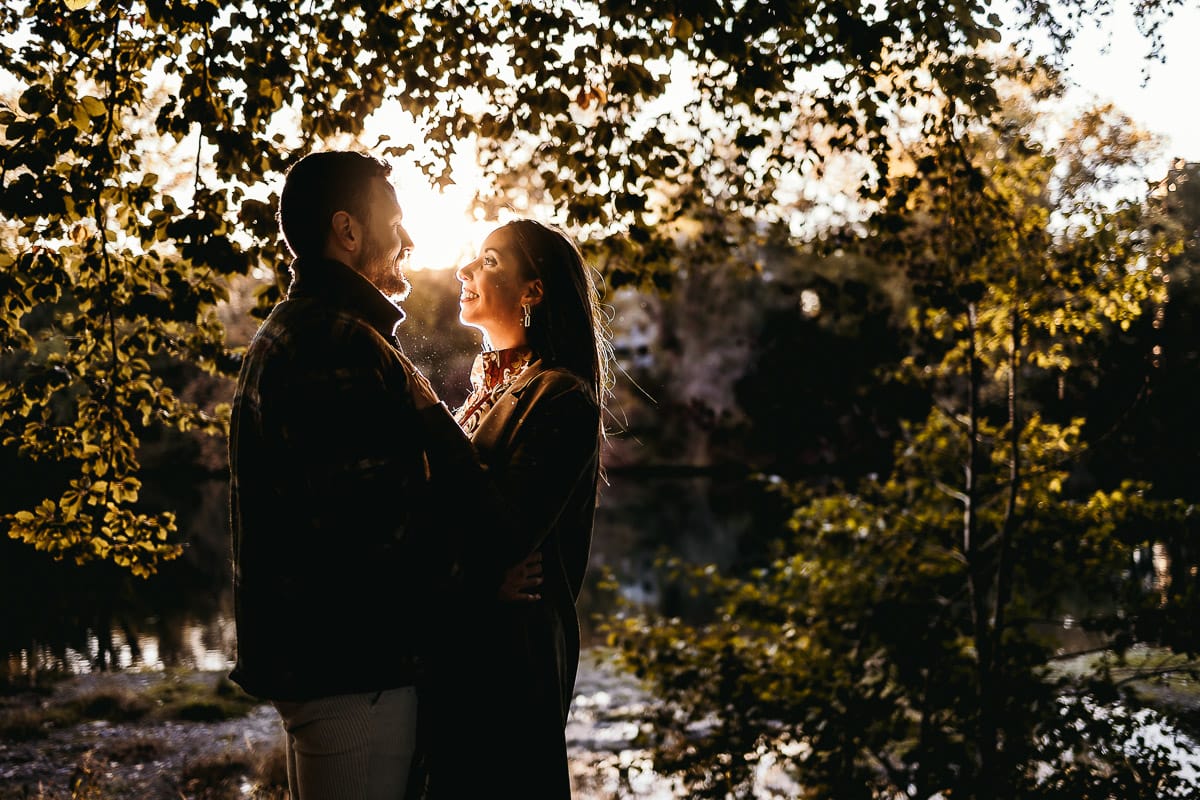 Prewedding a Torino, sul lungo Po al tramonto. Ritratto sulla riva del fiume con la magia dell'autunno sull'acqua. Coppia in controluce. Flare.